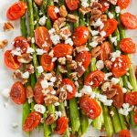 asparagus tomatoes and feta cheese on a white plate