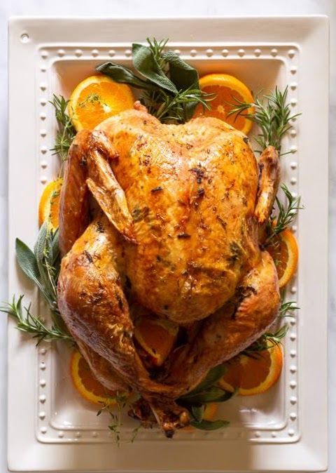 Turkey on a white platter with oranges.